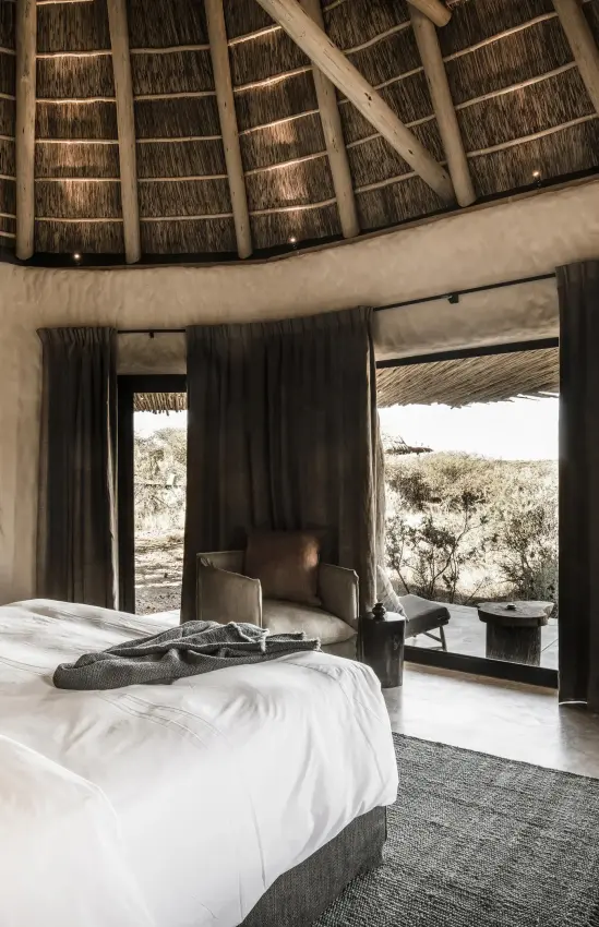 Circular bedroom with thatched roof and expansive landscape views, Omaanda, Windhoek, Namibia