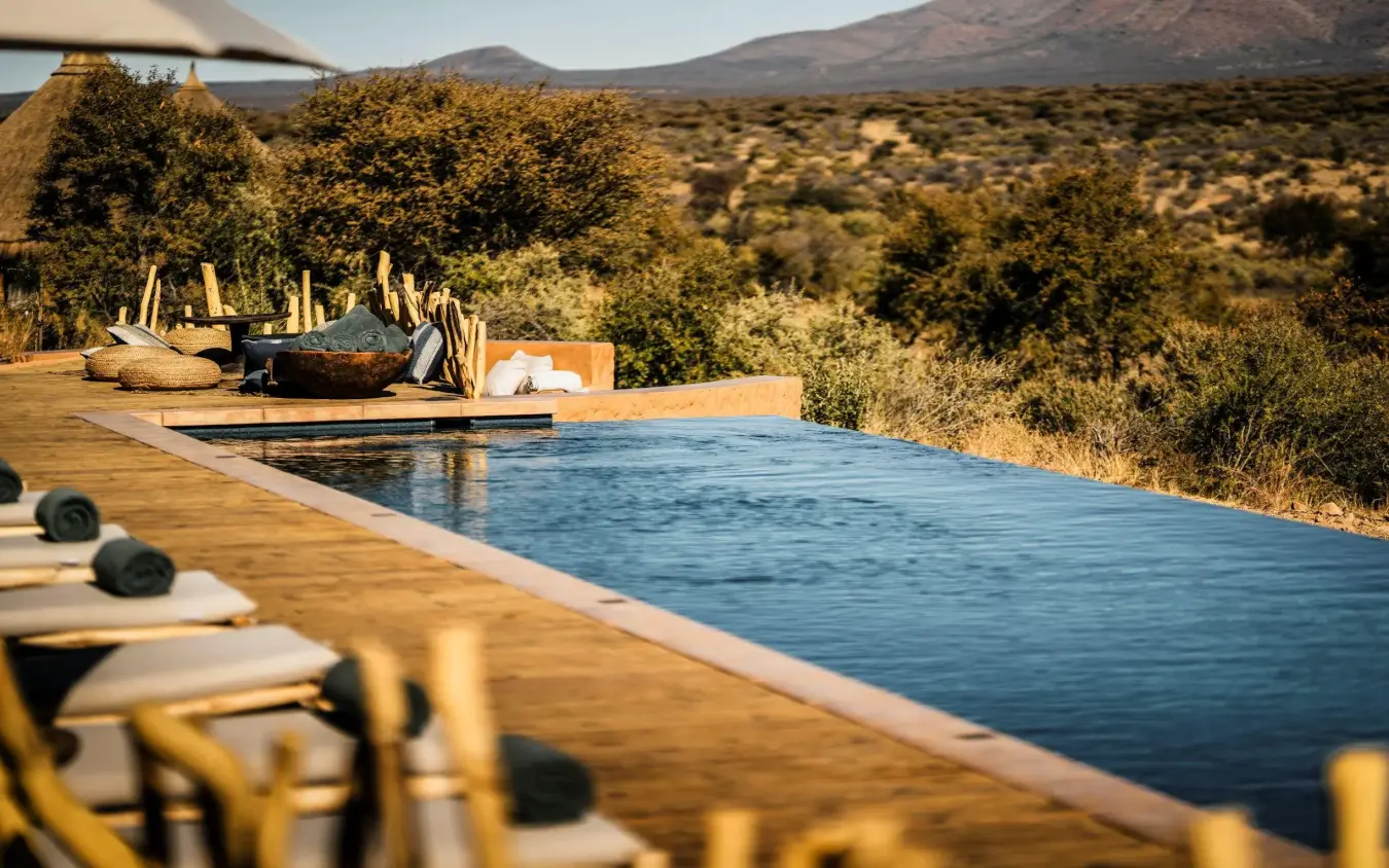 Infinity pool overlooking savanna landscape and mountains, Omaanda, Windhoek, Namibia