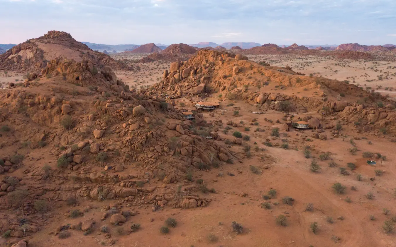 Rocky granite outcrops scattered across arid savanna landscape, Onduli Ridge, Damaraland, Namibia