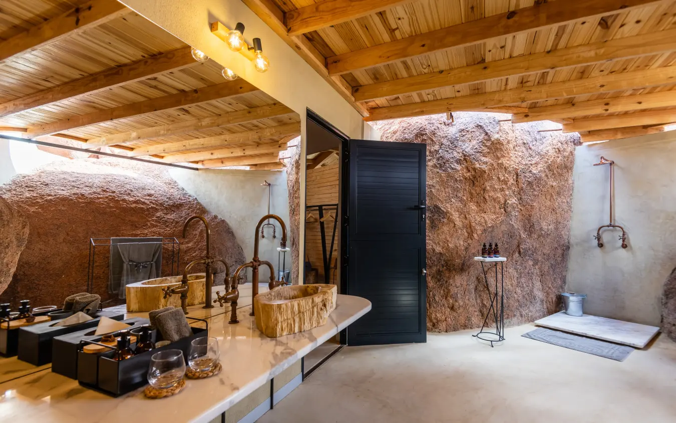 Luxury bathroom with wooden ceiling and natural stone walls, Onduli Ridge, Damaraland, Namibia