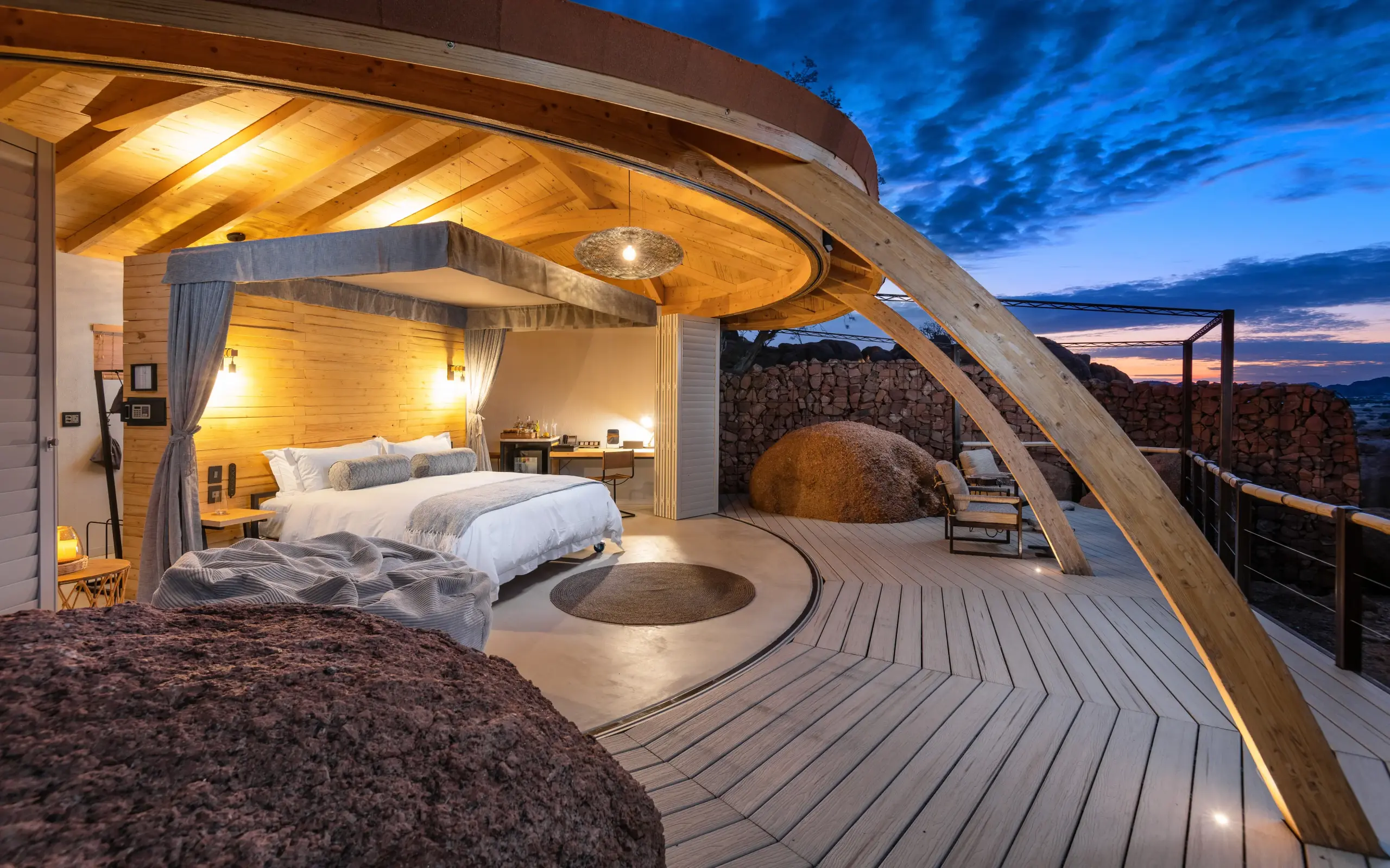 Bedroom suite with deck overlooking rocky landscape at dusk, Onduli Ridge, Damaraland, Namibia
