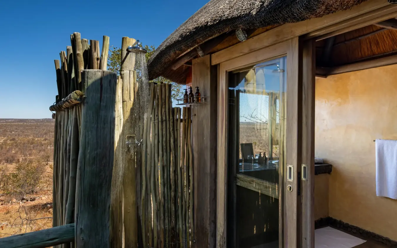 Outdoor shower enclosure with savanna landscape views, Ongava Lodge, Etosha National Park, Namibia