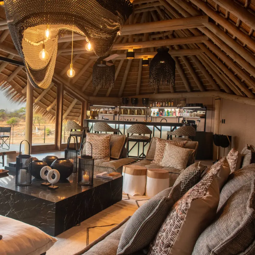 Luxury safari lodge lounge with waterhole view and thatched ceiling, Onguma Camp Kala, Etosha National Park, Namibia