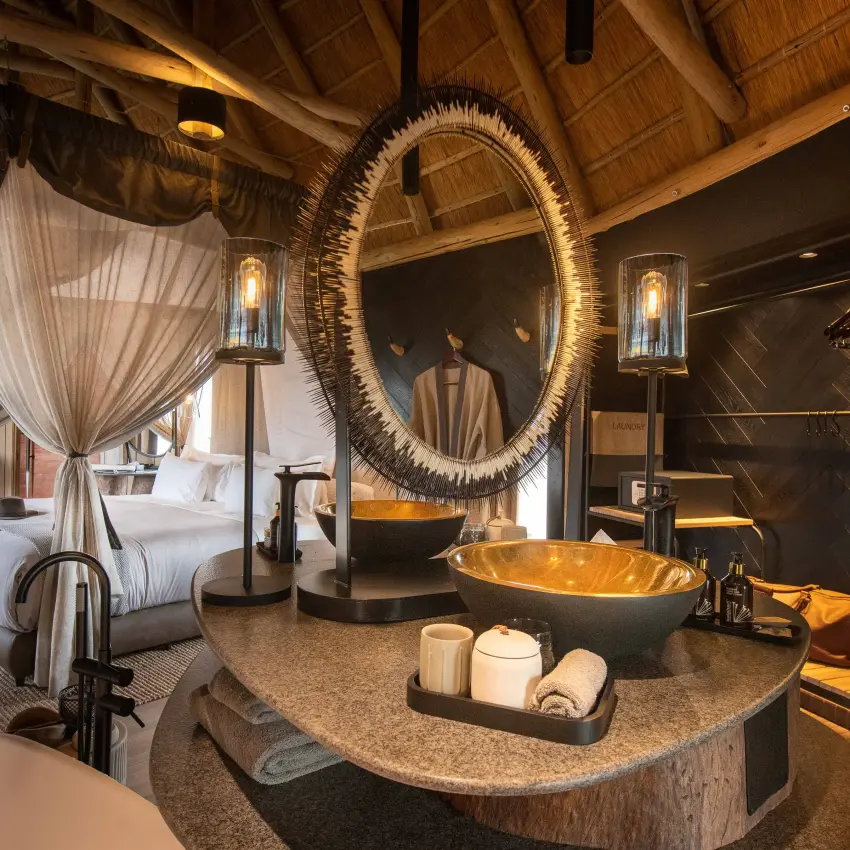 Luxury safari suite interior with canopy bed and freestanding bathtub, Onguma Camp Kala, Etosha National Park, Namibia