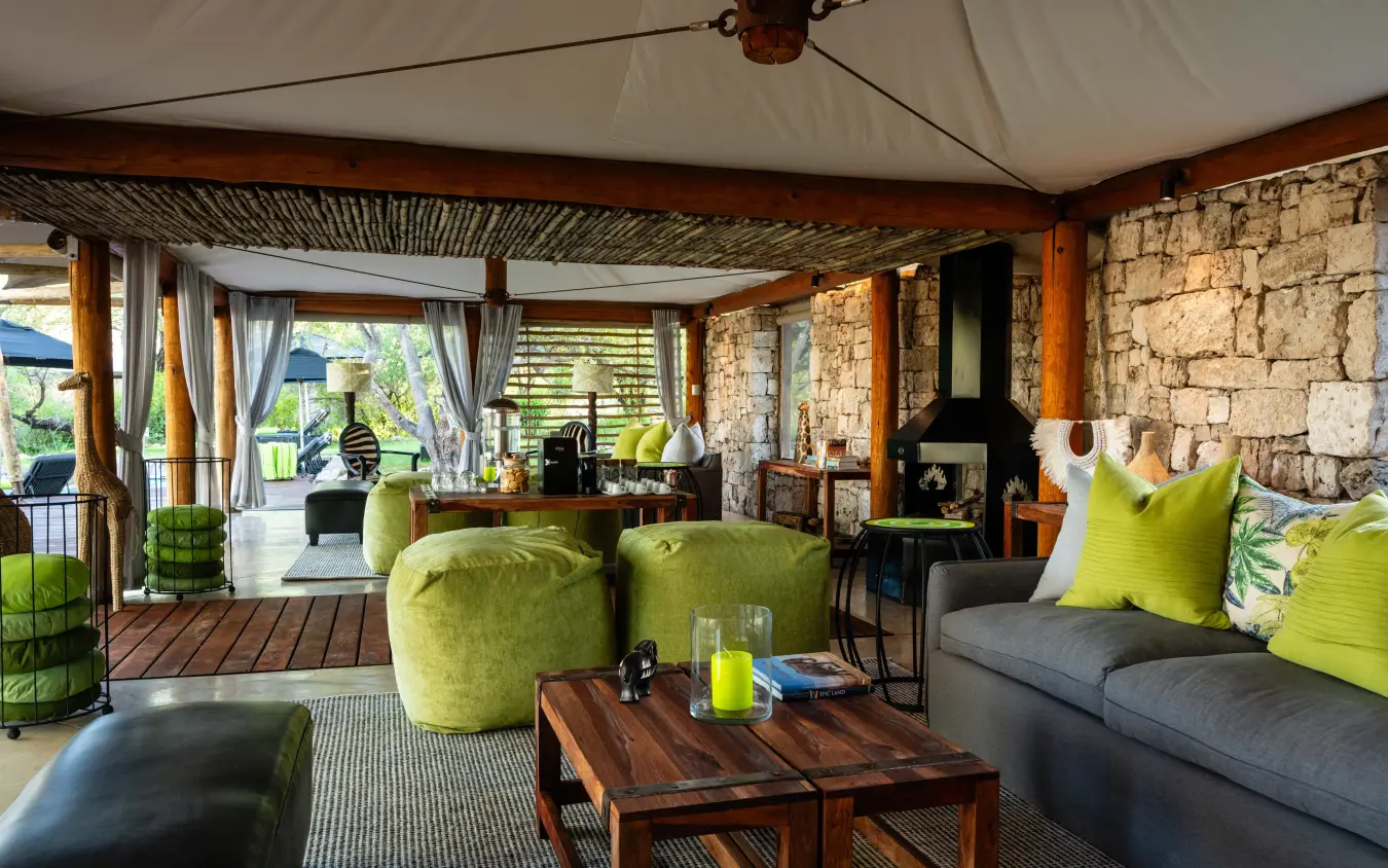 Luxury safari lodge interior with lime green accents and stone fireplace, Onguma Tented Camp, Etosha National Park, Namibia