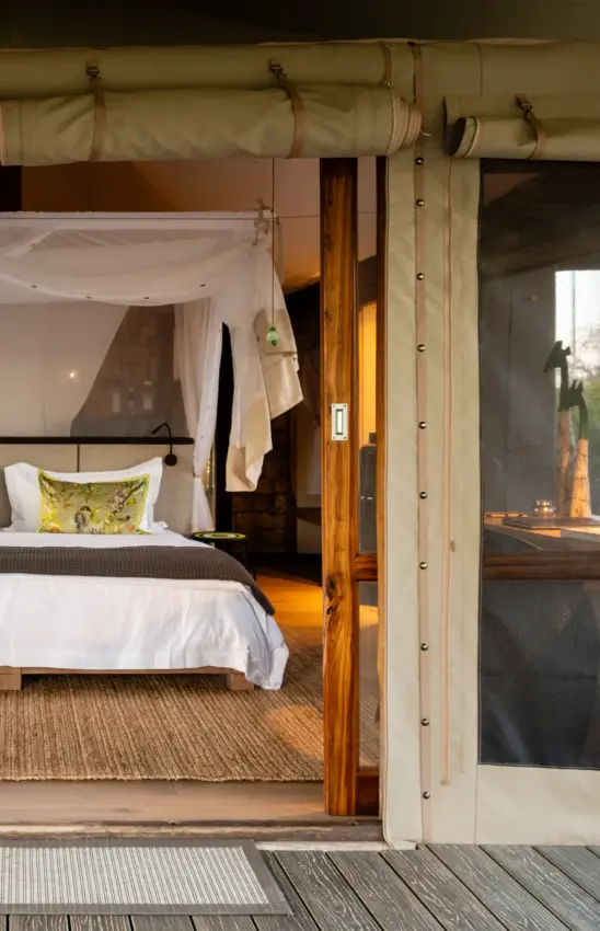 Safari lodge bedroom with canvas furnishings and wooden deck entrance, Onguma Tented Camp, Etosha National Park, Namibia