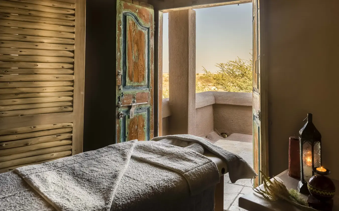 Bedroom with open doors overlooking savanna landscape at sunset, Onguma Tented Camp, Etosha National Park, Namibia