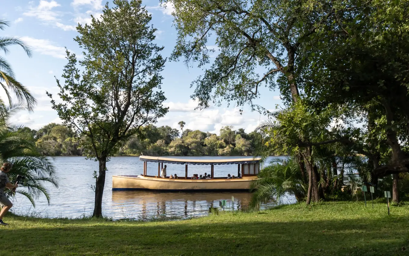 Traditional wooden boat moored on calm river at dusk, Palm River Hotel, Victoria Falls, Zimbabwe