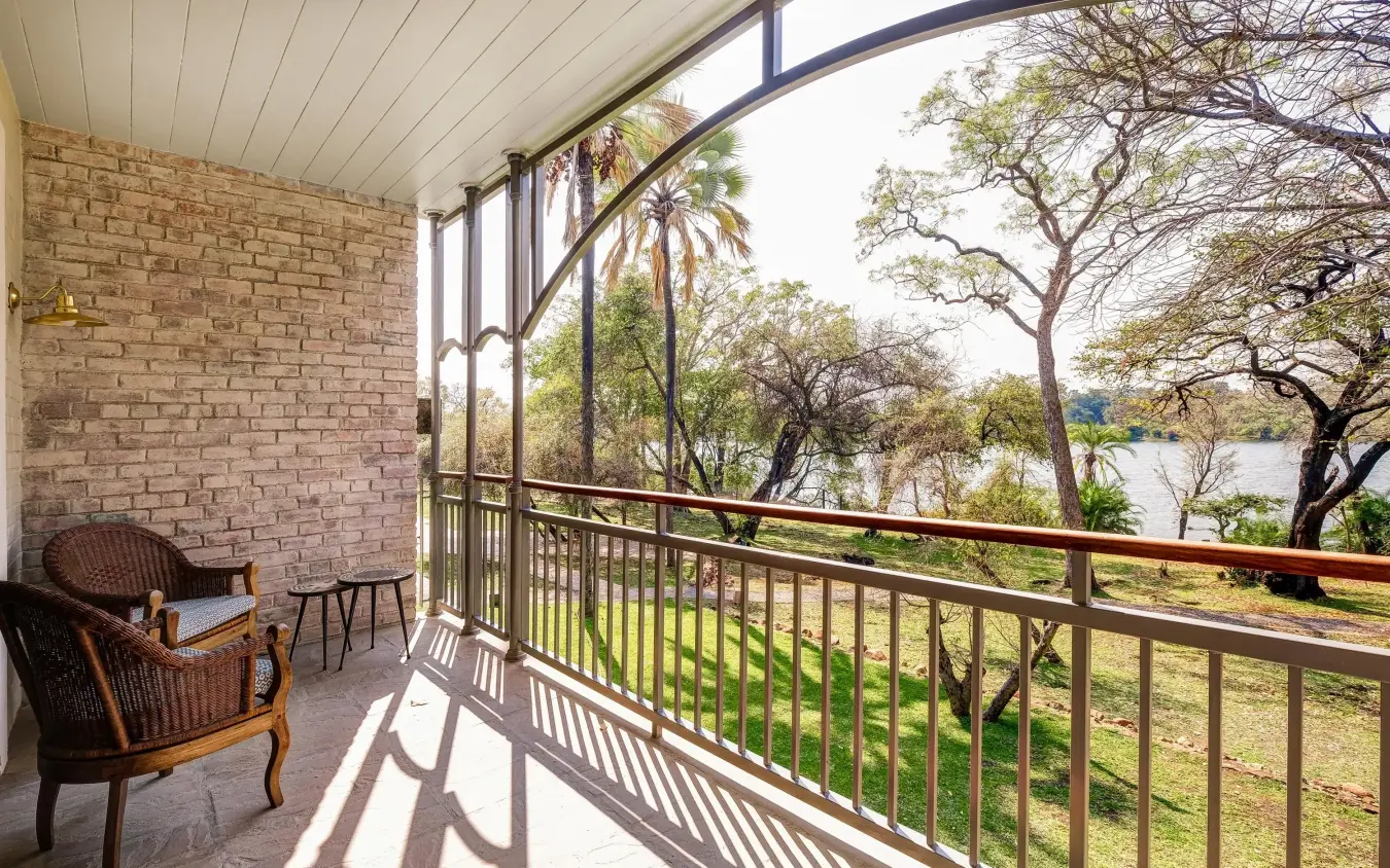 Screened deck overlooking river with native trees, Palm River Hotel, Victoria Falls, Zimbabwe