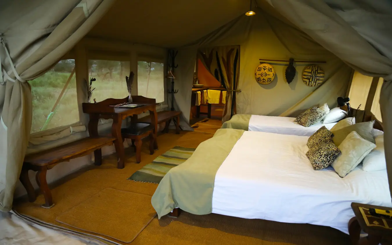 Luxury safari tent interior with beds and workspace, Pembazoni Camp, Serengeti National Park, Tanzania