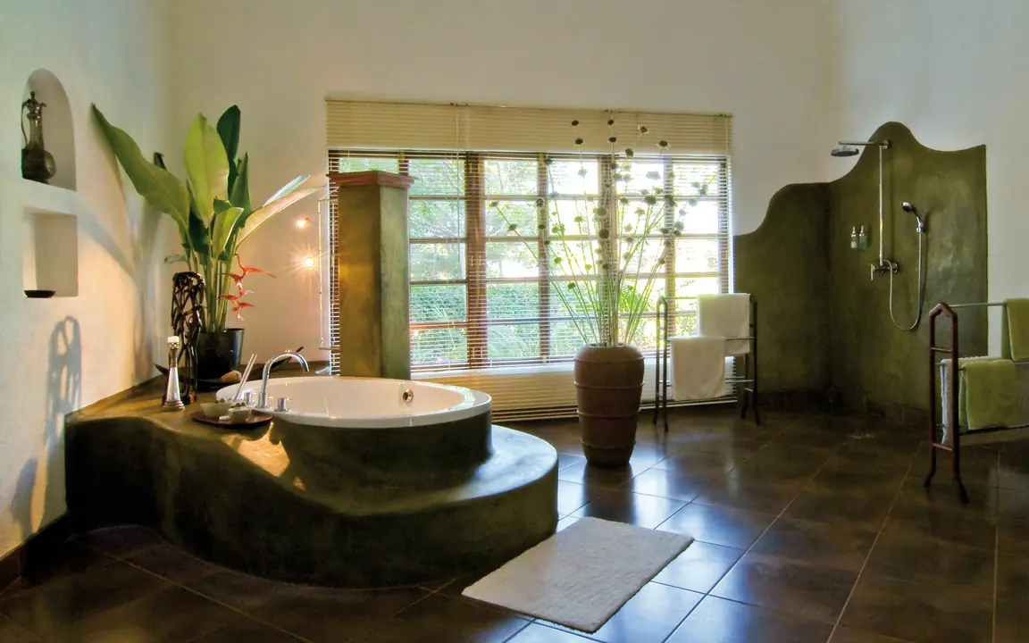 Luxurious spa bathroom with sunken tub and garden views, Plantation Lodge, Ngorongoro Crater, Tanzania