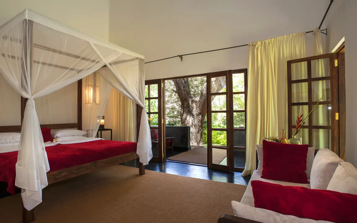 Spacious bedroom with canopy bed and garden views, Plantation Lodge, Ngorongoro Crater, Tanzania