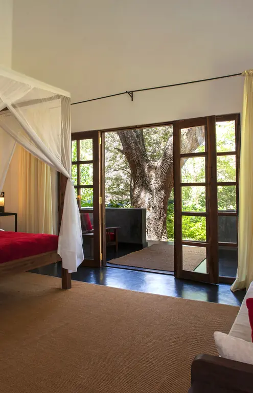 Spacious bedroom with canopy bed and garden views, Plantation Lodge, Ngorongoro Crater, Tanzania