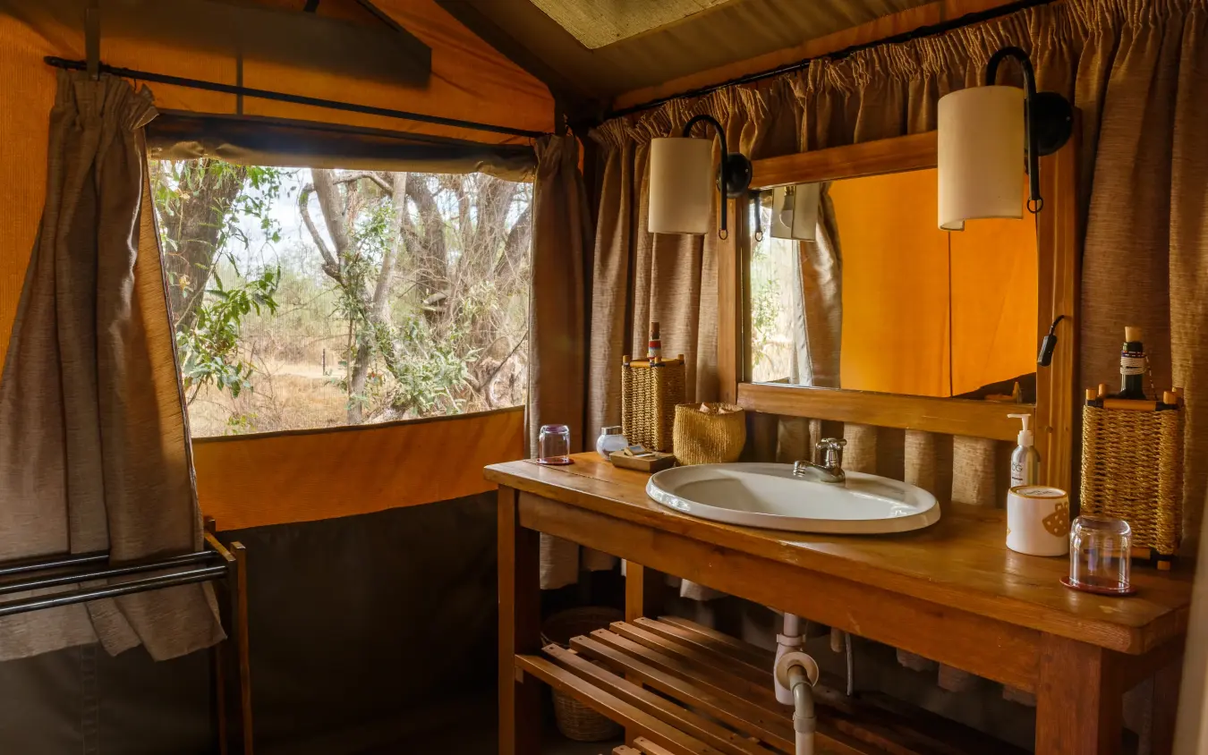 Luxury safari tent bathroom with wooden vanity and savanna views, Porini Amboseli Camp, Amboseli and Chyulu Hills, Kenya