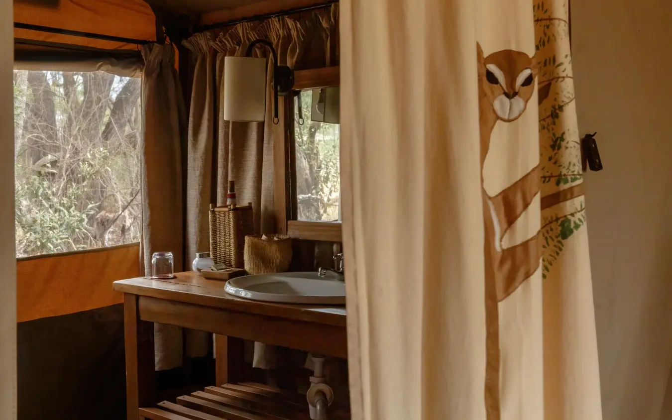 Luxury safari lodge bathroom with woodland views and decorative owl curtain, Porini Amboseli Camp, Amboseli and Chyulu Hills, Kenya
