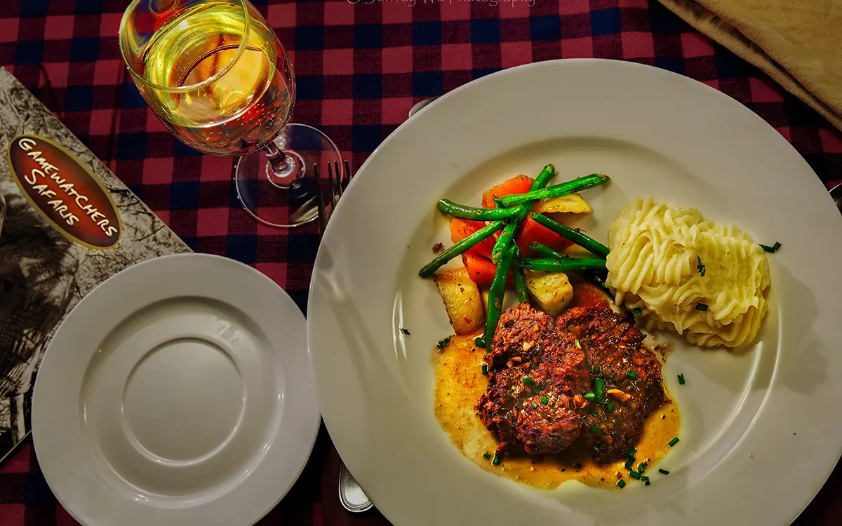 Fine dining plated meal with wine service on checkered tablecloth, Porini Amboseli Camp, Amboseli and Chyulu Hills, Kenya