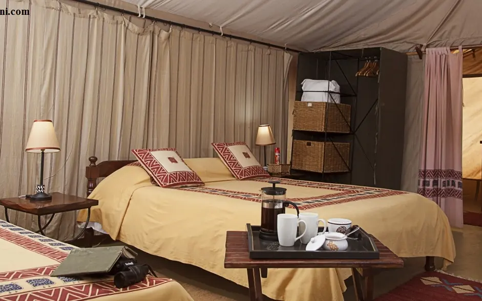 Luxury safari tent bedroom with cream linens and patterned cushions, Porini Amboseli Camp, Amboseli and Chyulu Hills, Kenya