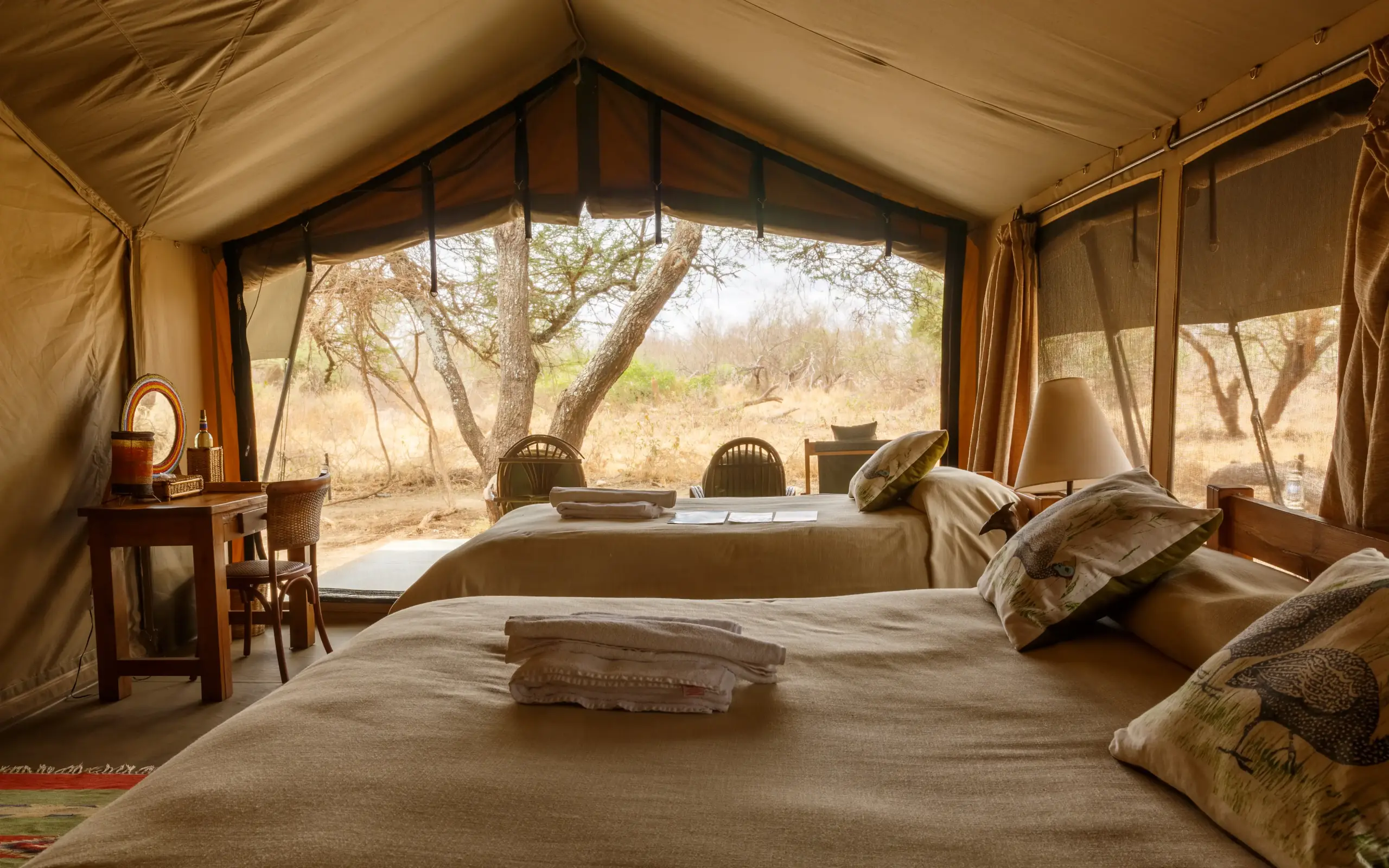 Safari tent interior with beds overlooking acacia trees and savanna landscape, Porini Amboseli Camp, Amboseli and Chyulu Hills, Kenya