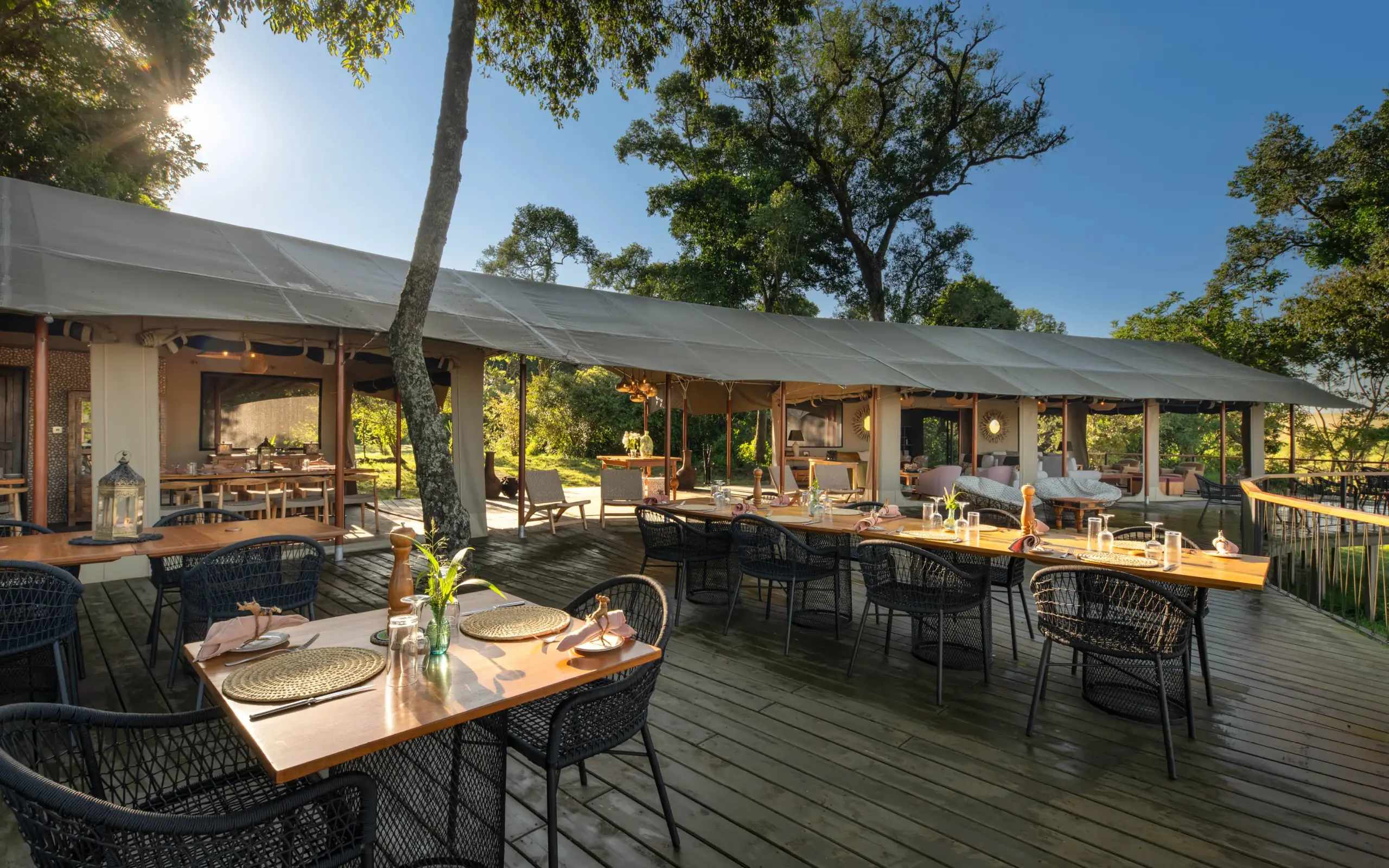 Shaded dining deck with tables overlooking savanna landscape, Rekero Camp, Maasai Mara, Kenya