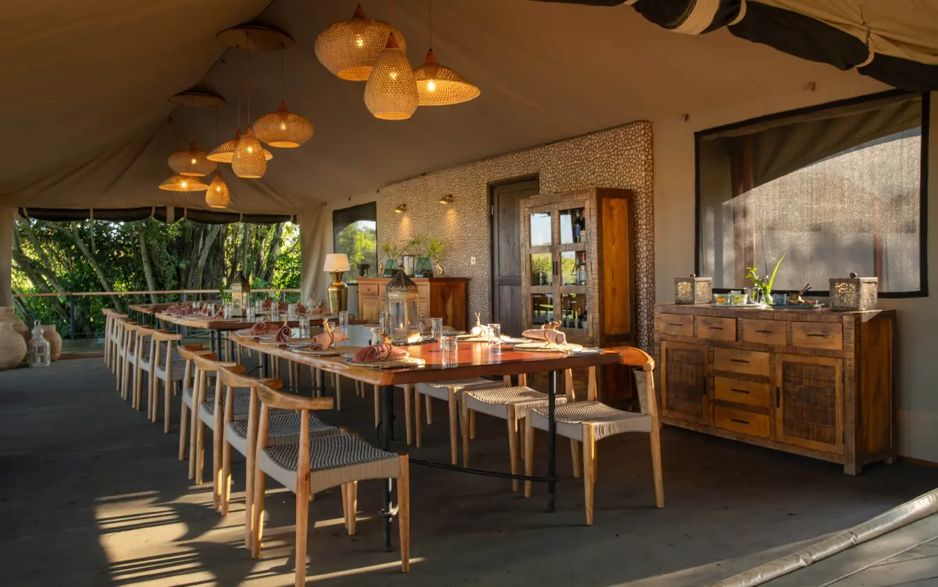 Open-air dining pavilion with long table and pendant lighting, Rekero Camp, Maasai Mara, Kenya
