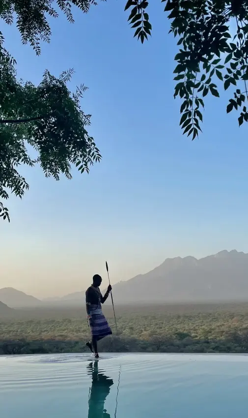 Guest at infinity pool overlooking savanna and mountains, Reteti House, Northern Kenya, Kenya
