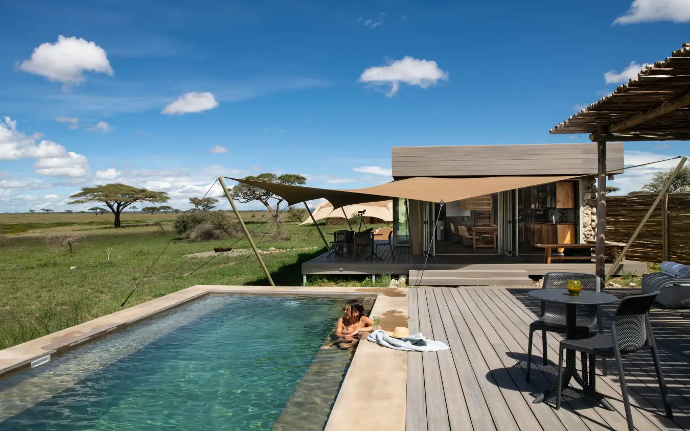 Infinity pool overlooking Serengeti plains with acacia trees, The Retreats at Namiri Plains, Serengeti National Park, Tanzania