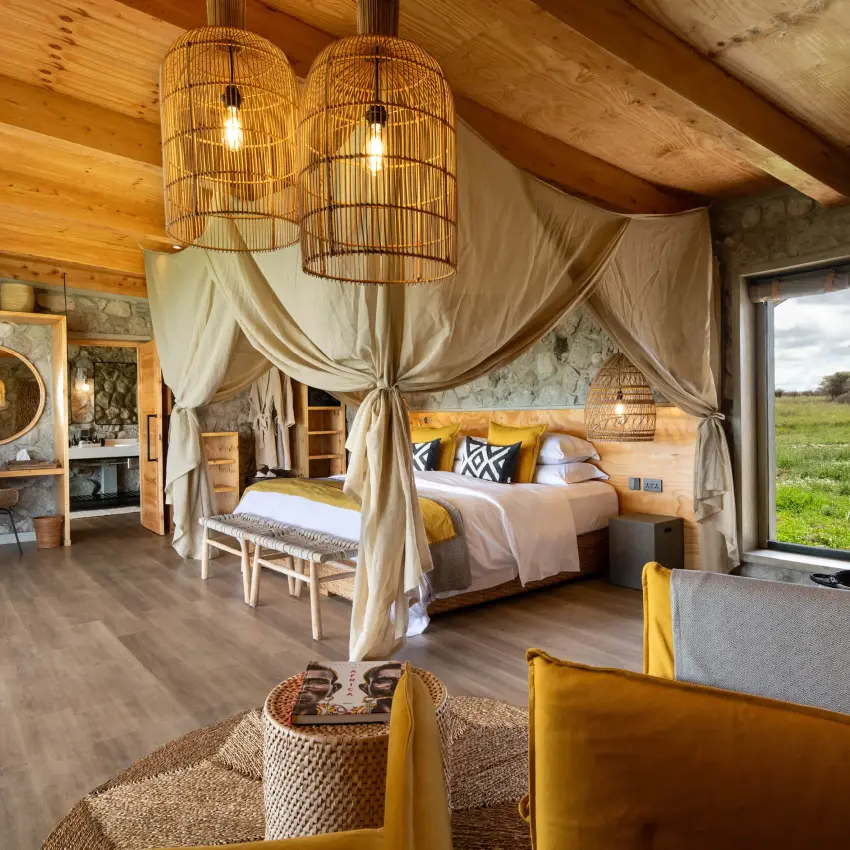 Spacious bedroom with canopy bed and yellow accents, The Retreats at Namiri Plains, Serengeti National Park, Tanzania