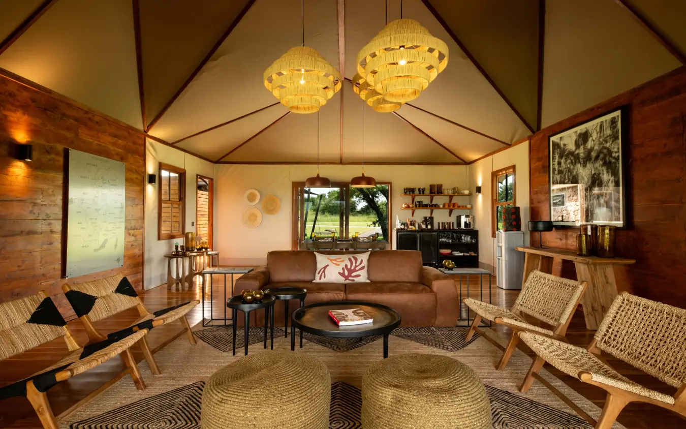 Interior view of safari lodge lounge with wooden furnishings, The Retreats at Sayari Camp, Serengeti National Park, Tanzania