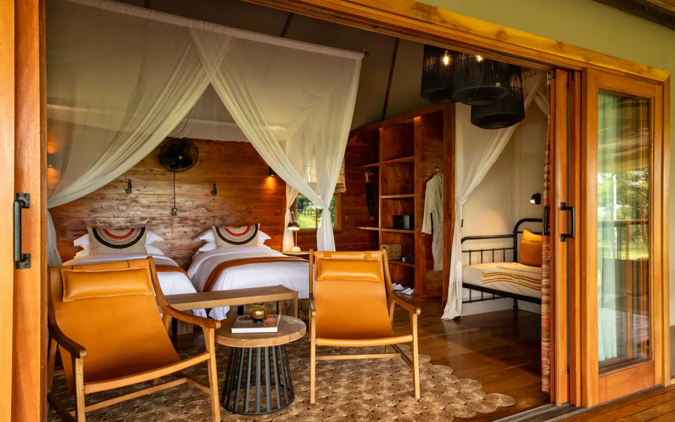 Luxury bedroom suite with canopy bed and sitting area, The Retreats at Sayari Camp, Serengeti National Park, Tanzania
