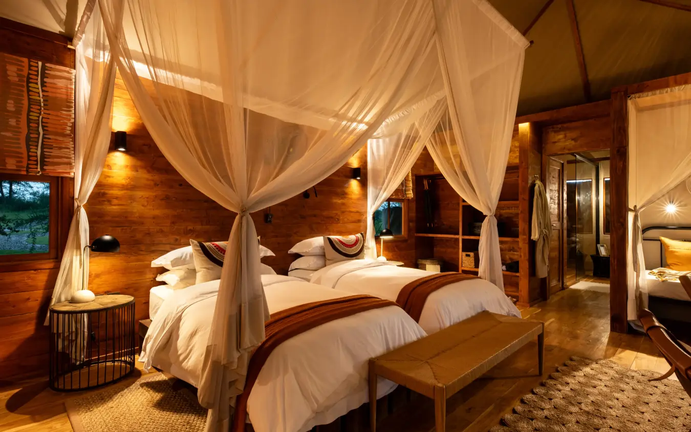 Luxury bedroom with four-poster canopy beds and wooden architecture, The Retreats at Sayari Camp, Serengeti National Park, Tanzania