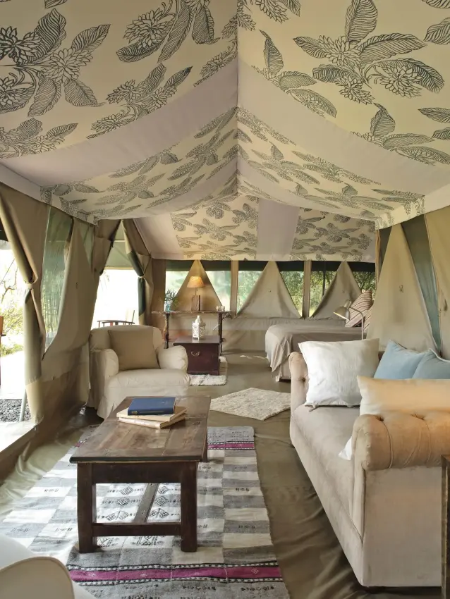 Interior of luxury safari tent with twin beds and seating, Richard’s River Camp, Maasai Mara, Kenya