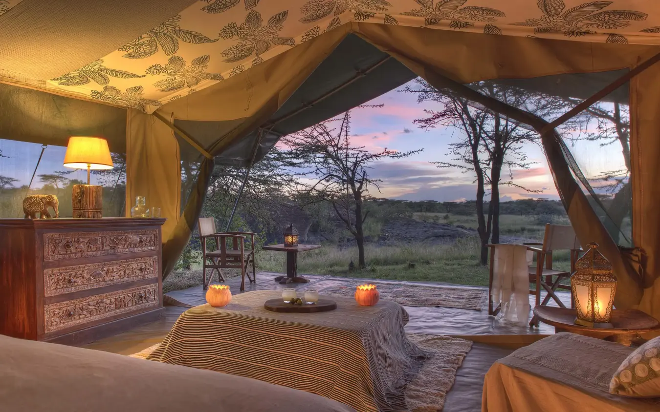 Safari tent bedroom with sunset views over savanna landscape, Richard’s River Camp, Maasai Mara, Kenya