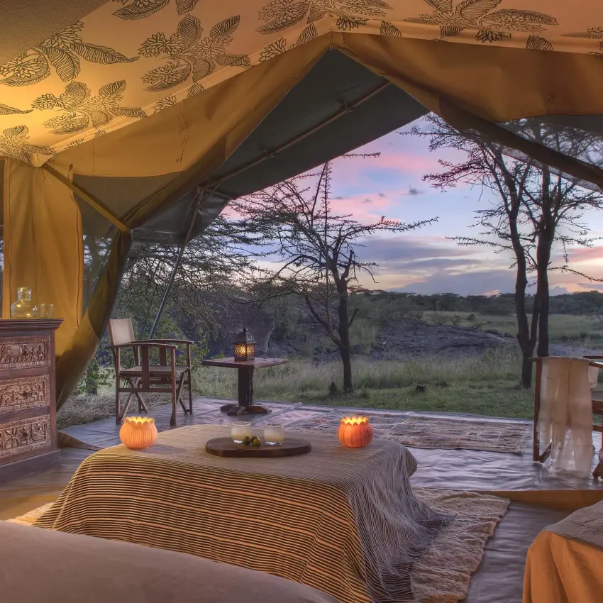 Safari tent bedroom with sunset views over savanna landscape, Richard’s River Camp, Maasai Mara, Kenya