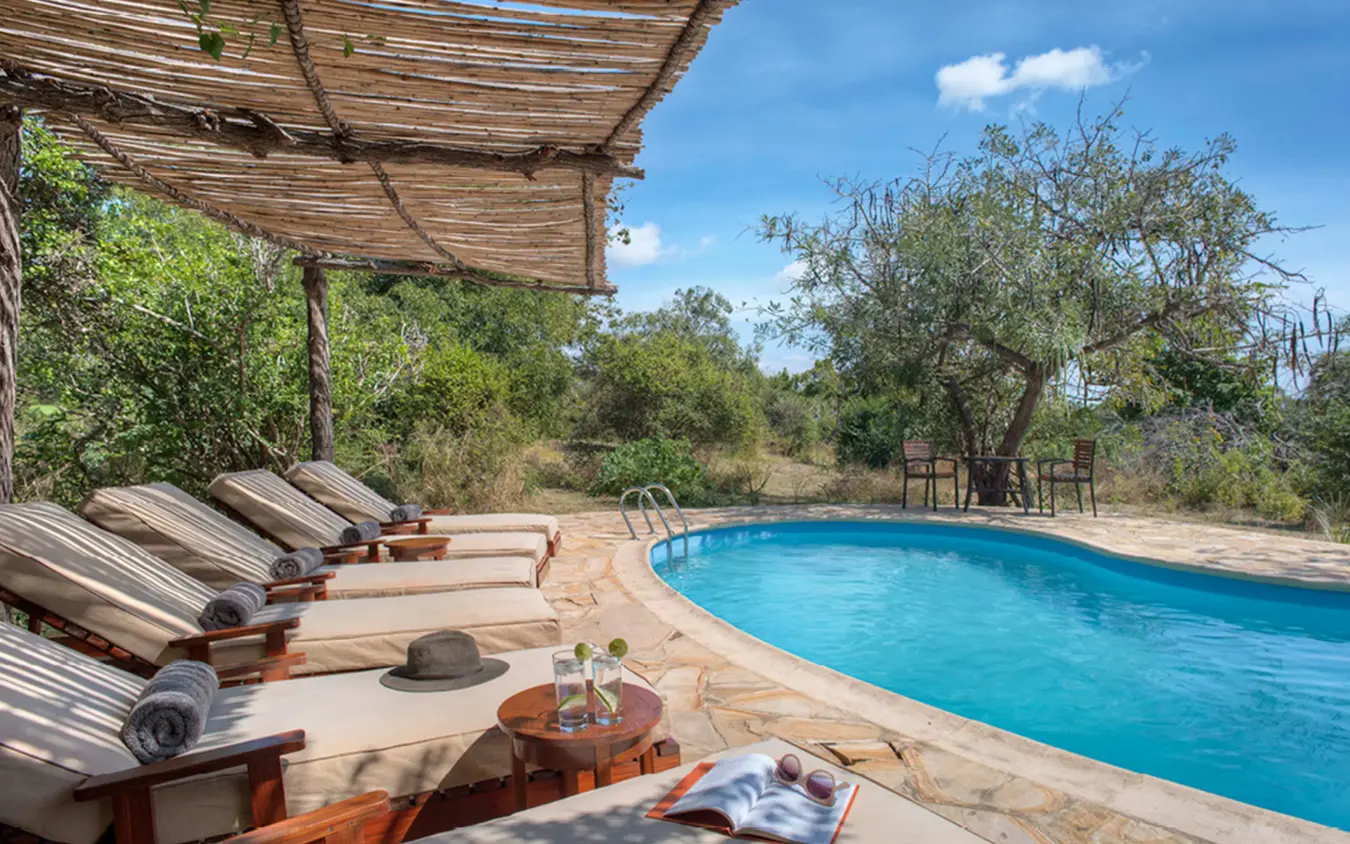 Resort pool with loungers and pergola shade structure, Roho ya Selous, Nyerere National Park, Tanzania