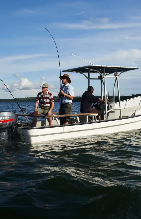 Fishing boat with guests and guide on open water, Rubondo Island, Tanzania