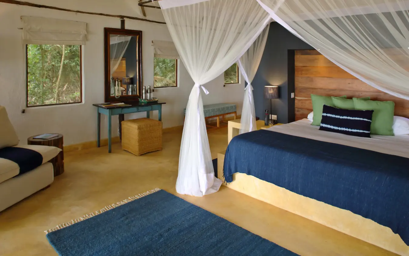 Spacious bedroom with four-poster bed and seating area, Rubondo Island Camp, Rubondo Island, Tanzania