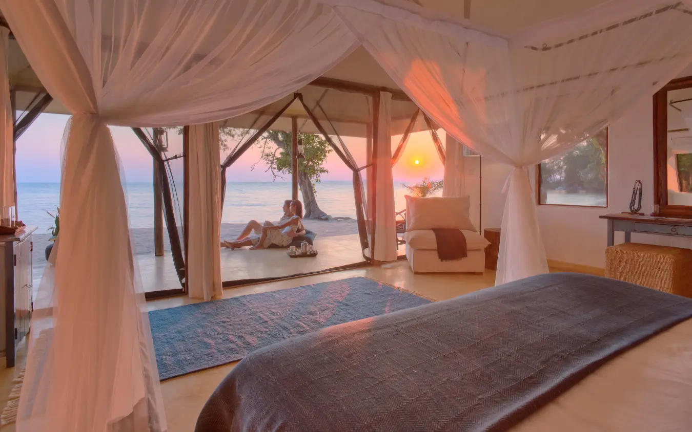 Beachfront bedroom with sheer curtains overlooking sunset water, Rubondo Island Camp, Rubondo Island, Tanzania