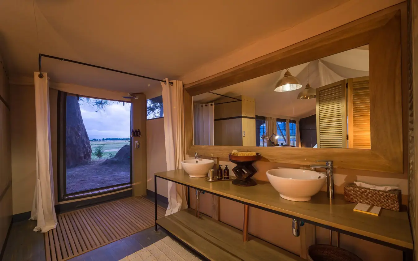 Luxury bathroom with dual sinks overlooking river landscape, Ruckomechi Camp, Mana Pools, Zimbabwe