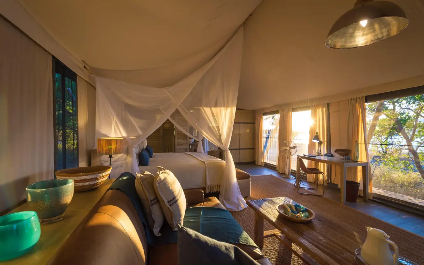 Spacious safari bedroom with draped canopy bed and view, Ruckomechi Camp, Mana Pools, Zimbabwe