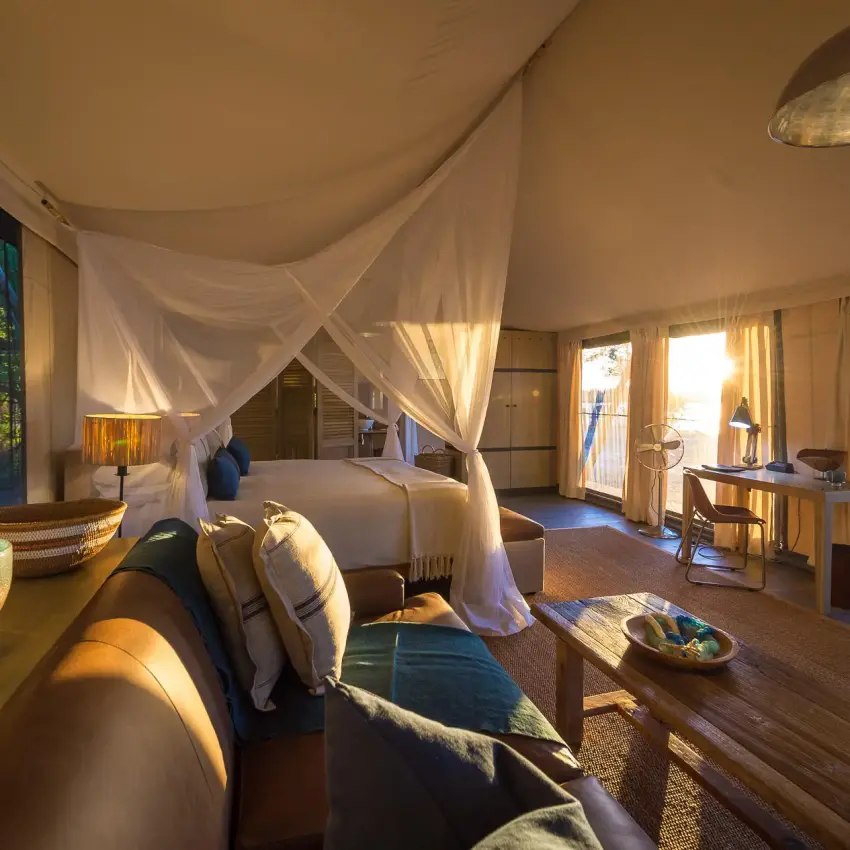 Spacious safari bedroom with draped canopy bed and view, Ruckomechi Camp, Mana Pools, Zimbabwe