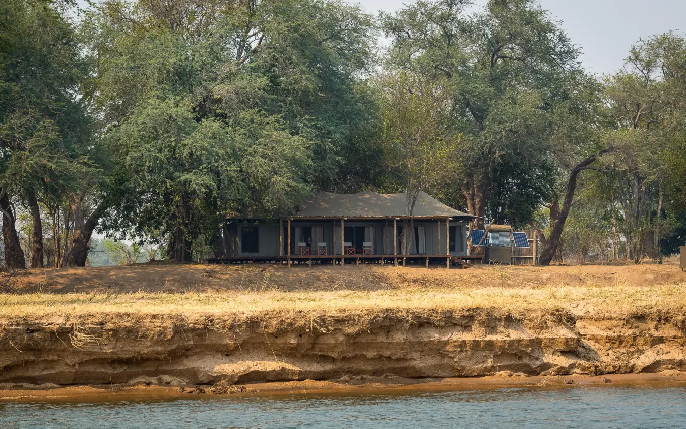 Riverside lodge building nestled among tall trees, Ruckomechi Camp, Mana Pools, Zimbabwe