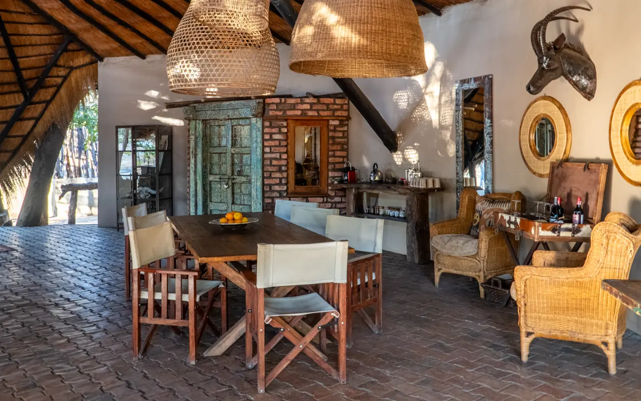 Open-air lounge with woven pendant lights and wooden furniture, Sable Valley Lodge, Hwange National Park, Zimbabwe