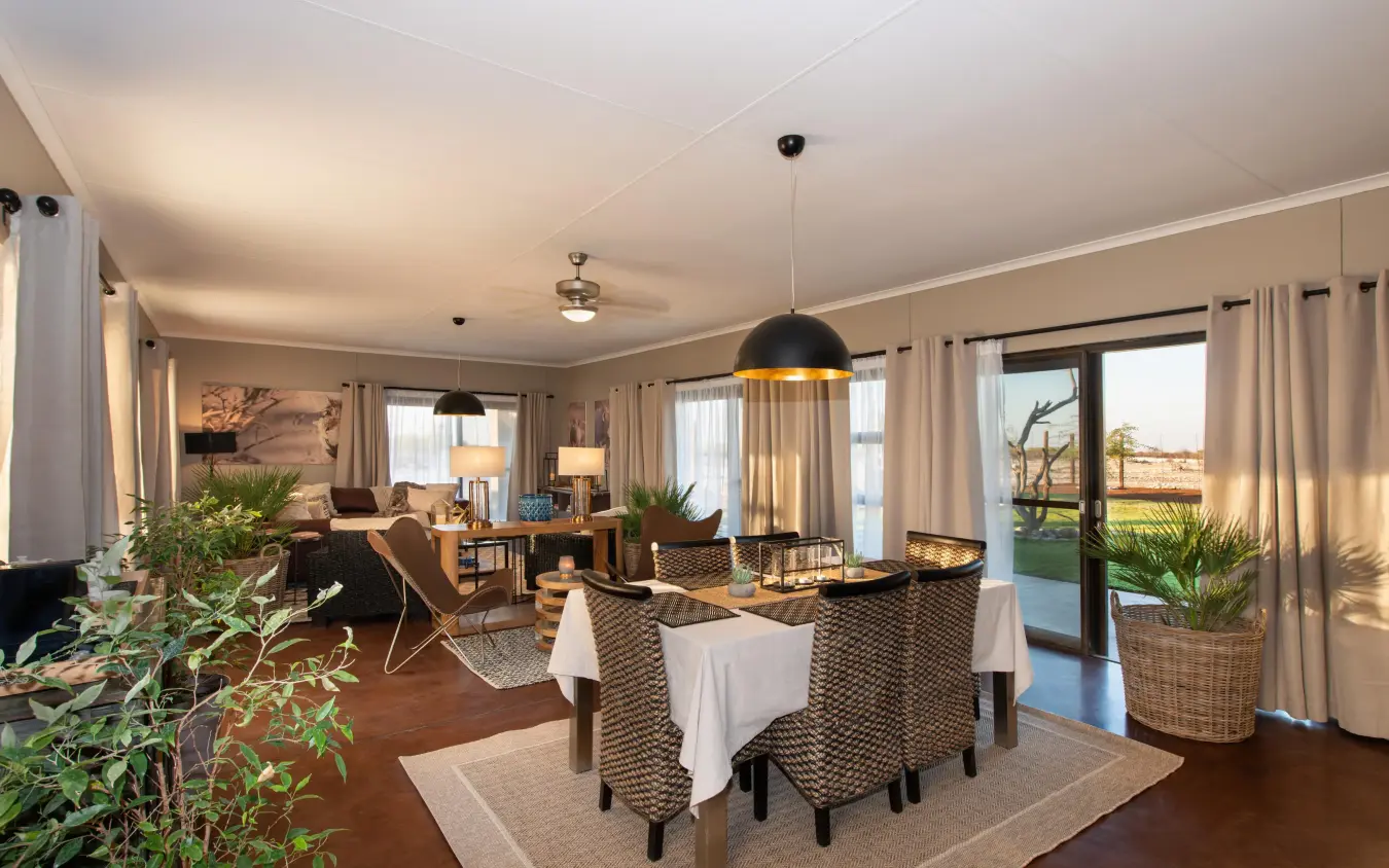 Open-plan living space with dining table and lounge seating, Safari House, Etosha National Park, Namibia