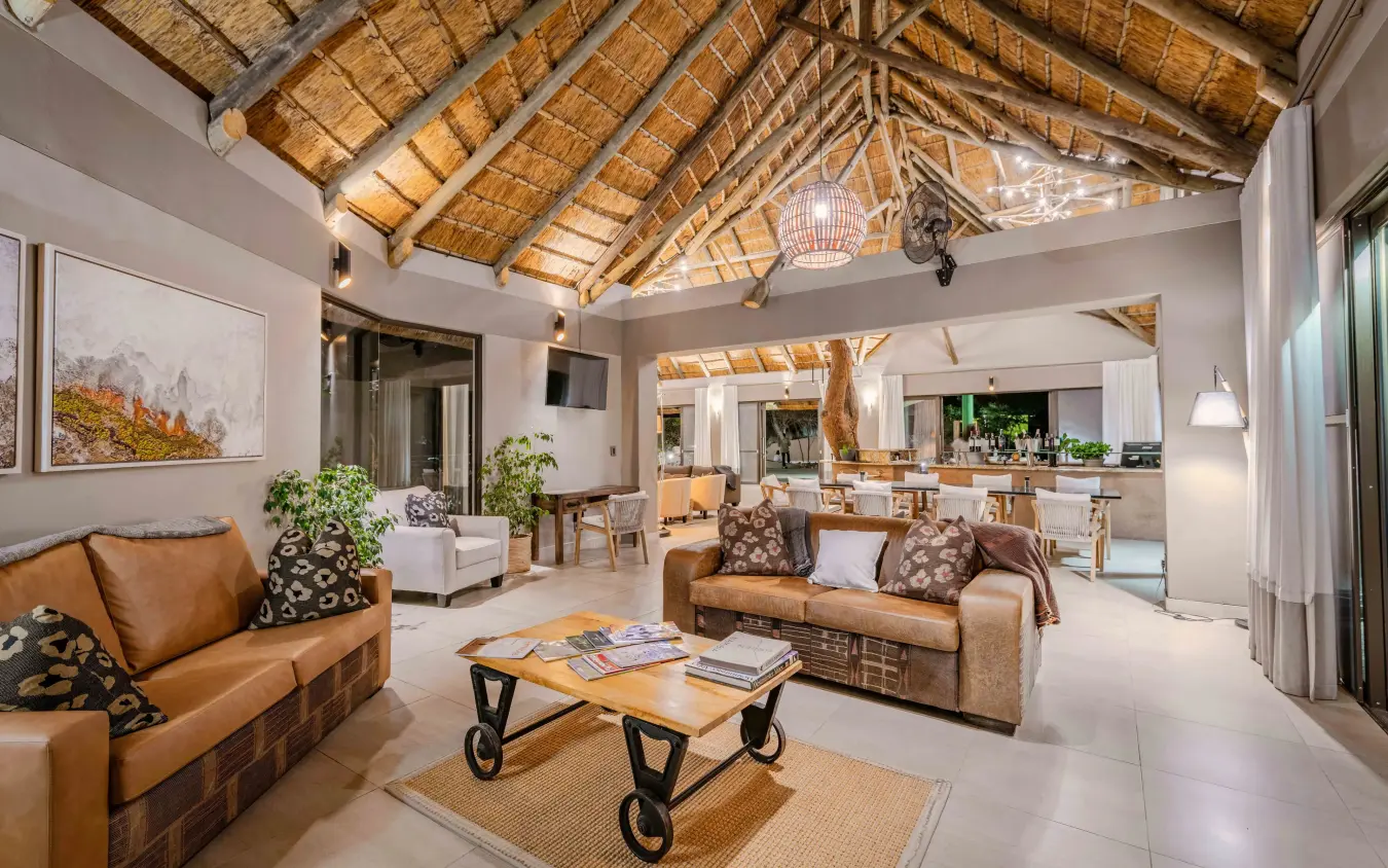 Open-plan lodge interior with thatched ceiling and leather furnishings, Safarihoek Lodge, Etosha National Park, Namibia