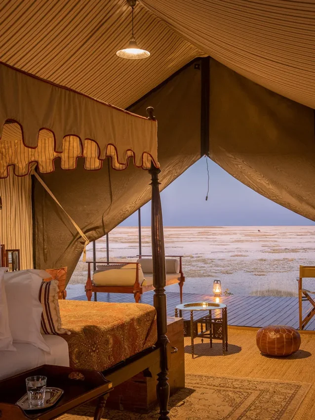 Canvas tent interior with four-poster bed overlooking salt pan, San Camp, Makgadikgadi Pans, Botswana
