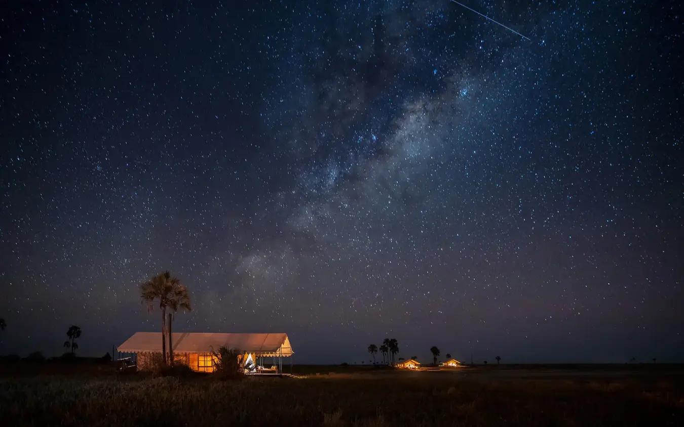 Illuminated safari tent under starlit sky at night, San Camp, Makgadikgadi Pans, Botswana