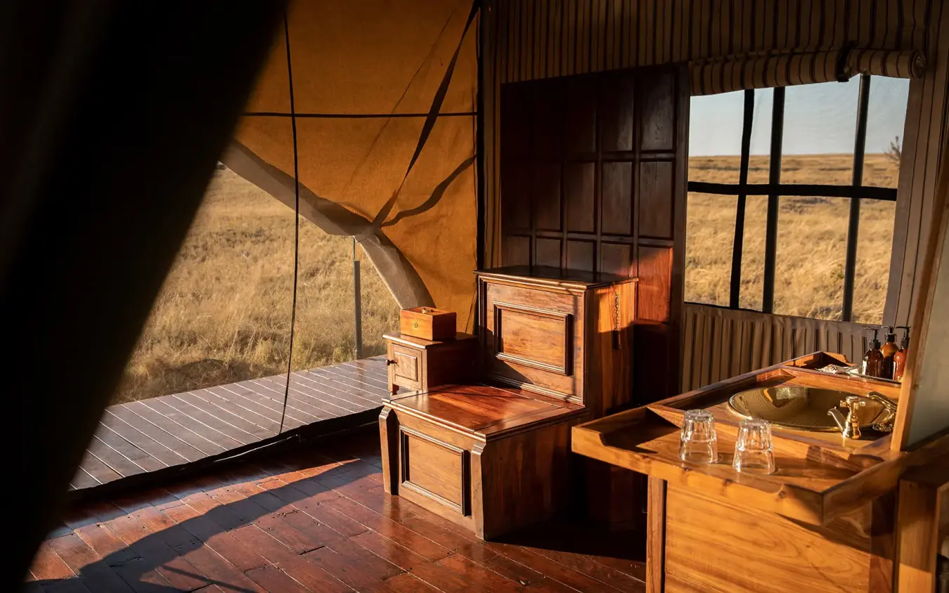 Interior of canvas guest tent with wooden furniture and savanna views, San Camp, Makgadikgadi Pans, Botswana