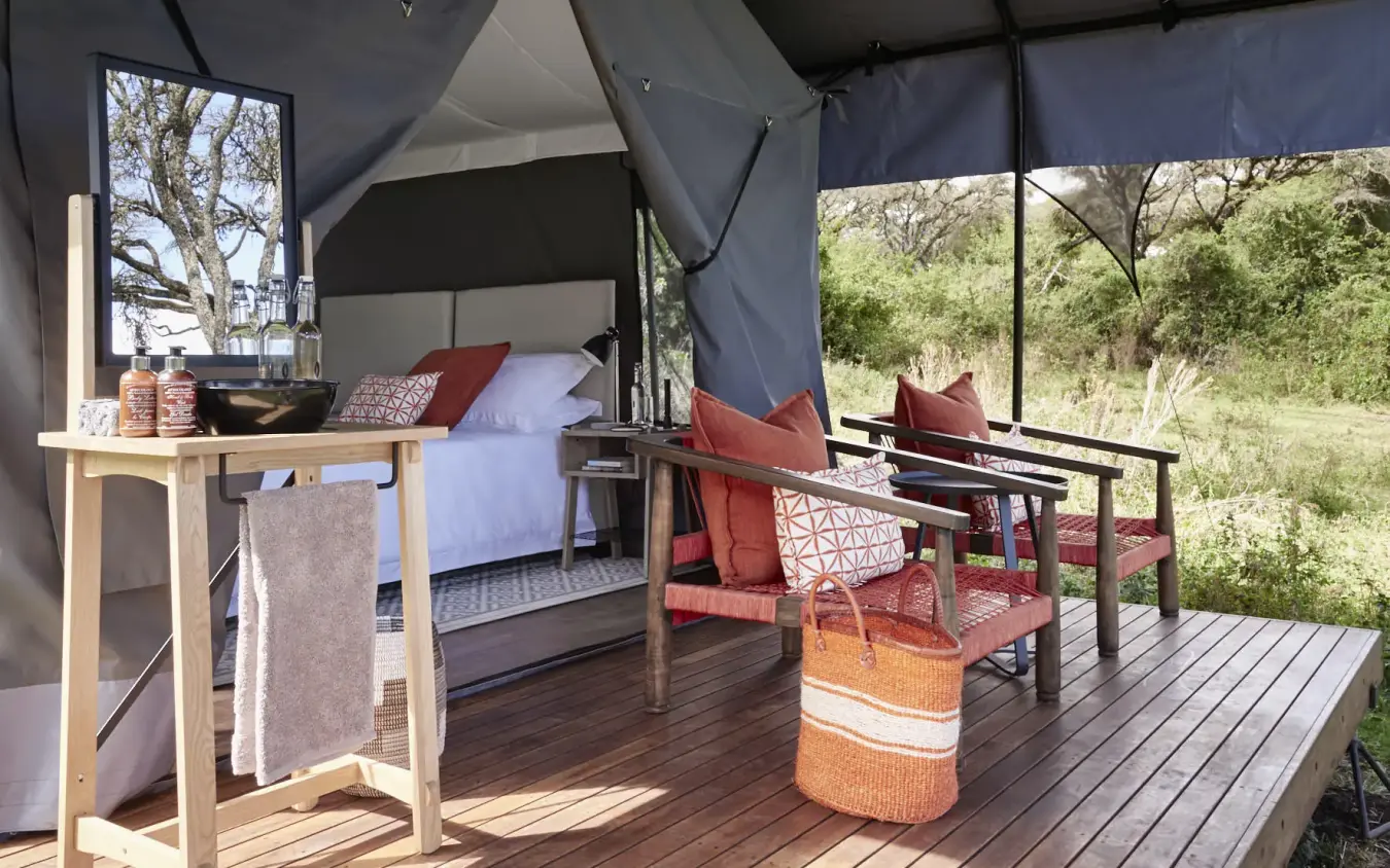 Luxury safari tent bedroom with private deck and savanna views, Sanctuary Crater Camp, Ngorongoro Crater, Tanzania