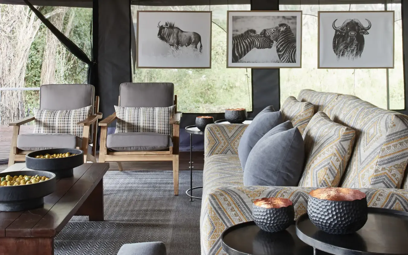 Safari lodge lounge with wildlife artwork and mountain views, Sanctuary Crater Camp, Ngorongoro Crater, Tanzania