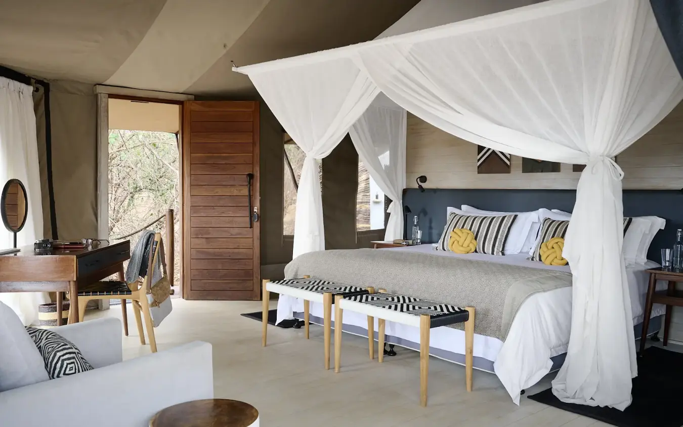 Luxury bedroom tent with white canopy bed and contemporary furnishings, Swala, Tarangire National Park, Tanzania